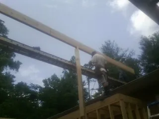 Carpenter setting a ridge beam over a new addition frame — Ice Dam Removal by Roofing Brothers in Totowa