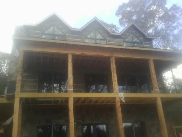 Dormers and porch framing on a large log home under construction — Roof Coating work by our crew in Totowa