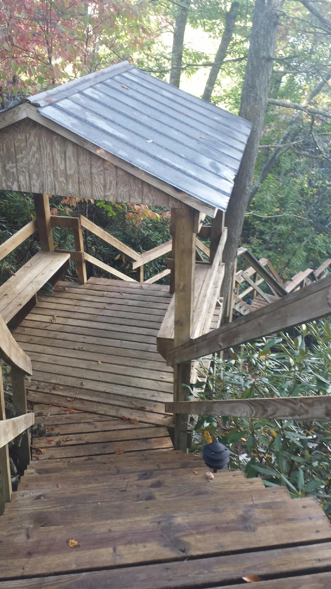 Metal roofed shelter over wooden steps on a wooded walkway — Skylight Repair & Installation work by our crew in Totowa