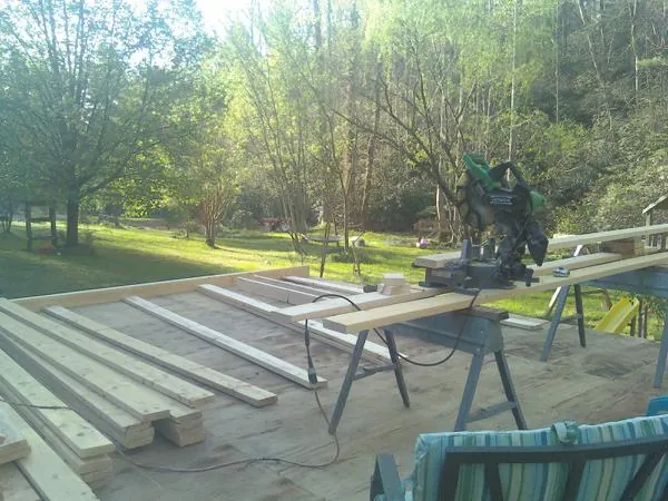 Miter saw and framing lumber on a deck under construction in Totowa
